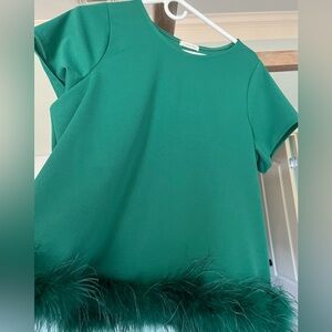 Fun boutique flare style top with feather trim!